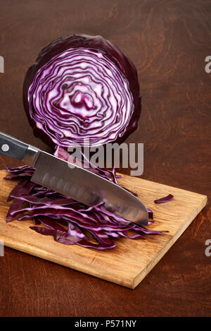 Affettare il cavolo rosso con coltello da cucina Foto Stock