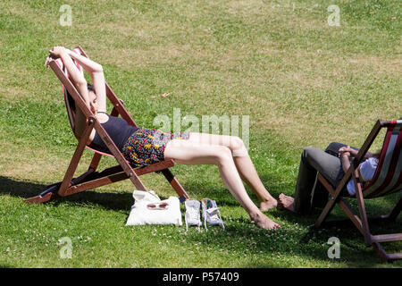 Bath, Regno Unito, 25 Giugno, 2018. Come bagno gode di un altro calda e soleggiata giornata di una donna seduta in bagno's Parade Gardens è raffigurato approfittando del bel tempo e il sole caldo, forecasters prevedono che il clima caldo proseguirà anche nella prossima settimana. Credito: lynchpics/Alamy Live News Foto Stock