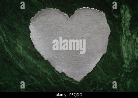 Cuore bianco a forma di foglio di carta su un sfondo marmo per amore note Foto Stock
