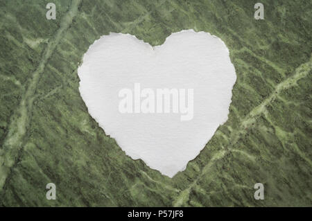 Cuore bianco a forma di foglio di carta su una sbiadita Sfondo marmo per amore note Foto Stock
