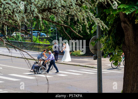 Strasburgo, uomo maturo spingendo donna anziana in carrozzina, donna ciclista, attraversamento pedonale, new-weds, fotografo, street, Alsazia, Europa Foto Stock