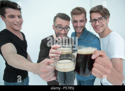 Close up.boccali di birra nelle mani di un gruppo di uomini Foto Stock