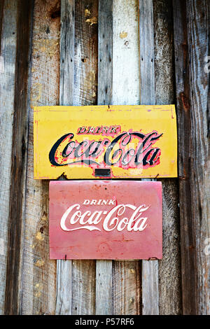Antica o vintage Coca-Cola cartelli pubblicitari imbastito su un lato di una vecchia cabina in legno in Alabama rurale. Foto Stock