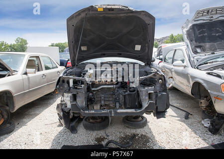 Il vano motore del relitto di una vettura rivela parti mancanti, compresi il paraurti, il radiatore e la parte del motore Foto Stock