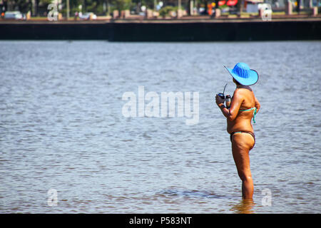 Donna locale in piedi con la tazza di mate sulle sponde del Rio de la Plata a Montevideo, Uruguay. Montevideo è la capitale e la città più grande dell'Uruguay Foto Stock