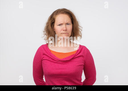 Funny giovane donna europea è offeso. Lei sta cercando con incredulità per telecamera. Hanno qualche sospetto pensieri Foto Stock