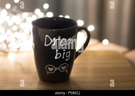 Grande Sogno mug sulla cima di legno e le luci bokeh sullo sfondo Foto Stock