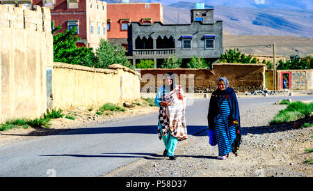 Due giovani donne in abito tradizionale a piedi nel villaggio di Tamtetoucht ai piedi dell'Alto Atlante in Marocco Foto Stock