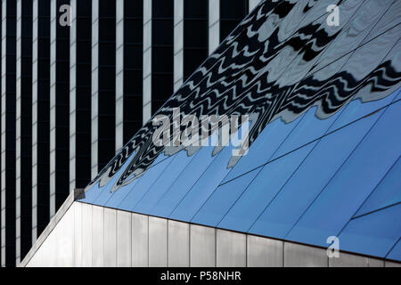 Frammento di La facciata dell'edificio della Biblioteca Nazionale della Lettonia in acciaio e vetro con la riflessione di colonne Foto Stock