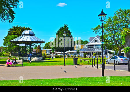 Un Estate in scena con un tradizionale bandstand sul verde a Christchurch Quay con il Boathouse café restaurant in background Foto Stock