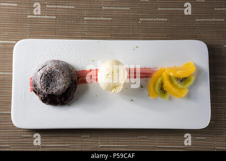 Cioccolato morbido con gelato alla vaniglia e frutta fresca Foto Stock