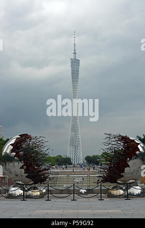 Guangzhou - Cina - Giugno 09, 2018; famosa torre del Cantone in background con i visitatori e & scultura moderna in primo piano durante una tempesta estiva. Foto Stock