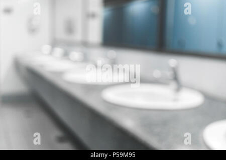 Sfocata sullo sfondo di un appalto pubblico di servizi igienici e bagno interno bianco con lavabo e lavello o lavabo, sfocata del recipiente di lavaggio ed il bacino con la macchia Foto Stock