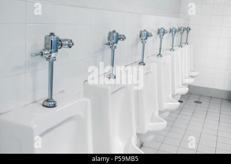 Appalto pubblico di servizi igienici e bagno interno con il bianco orinatoi, Close-up di lavare il recipiente e il vaso o un orinatoio gli uomini con la macchia sporca nel WC. Foto Stock