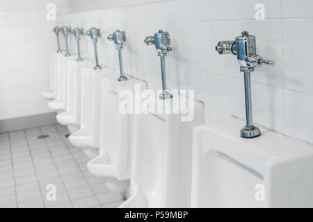 Appalto pubblico di servizi igienici e bagno interno con il bianco orinatoi, Close-up di lavare il recipiente e il vaso o un orinatoio gli uomini con la macchia sporca nel WC. Foto Stock