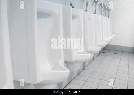 Appalto pubblico di servizi igienici e bagno interno con il bianco orinatoi, Close-up di lavare il recipiente e il vaso o un orinatoio gli uomini con la macchia sporca nel WC. Foto Stock