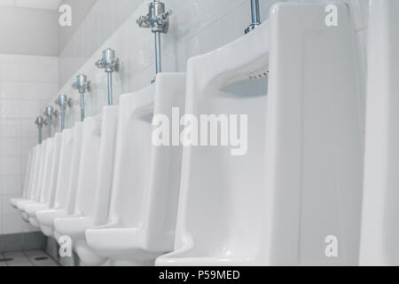 Appalto pubblico di servizi igienici e bagno interno con il bianco orinatoi, Close-up di lavare il recipiente e il vaso o un orinatoio gli uomini con la macchia sporca nel WC. Foto Stock