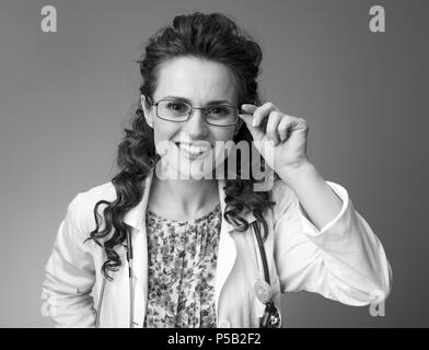 Ritratto di felice paediatrist donna in bianco manto medico isolato su sfondo Foto Stock