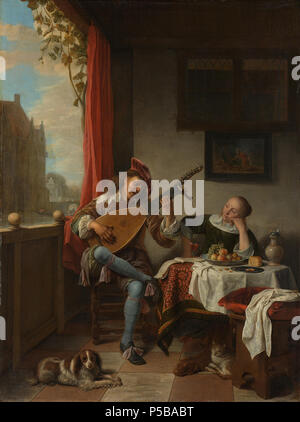 De luitspeler . Nederlands: De luitspeler. In een kamer speelt een jonge man op de luit voor een vrouw zittend en luisterend aan een tafel. Op tafel een schaal incontrato frutta, covata, een kruik en een openliggend muziekboek. Op de vloer een hond en een kat, aan de muur hangt een schilderijtje van Pyramus en Tisbe. ; Hendrick Martensz Sorgh (1611-1670), olieverf op paneel, 1661 . 1661. N/A 421 De luitspeler Rijksmuseum SK-A-495 Foto Stock