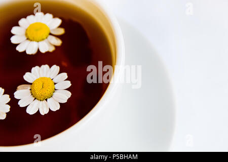 Tazza di tè e chamomiles. Foto Stock