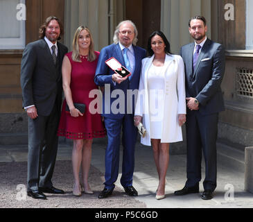 Cantante e cantautore Barry Gibb, con sua moglie, Linda e bambini, Michael (destra), Alexandra e Ashley (sinistra) a Buckingham Palace di Londra, dopo che egli fu nominato cavaliere dal Principe di Galles durante una cerimonia di investitura. Foto Stock