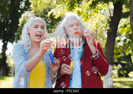 Bella coppia felice soffiando bolle di sapone Foto Stock