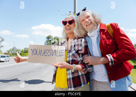 Felice coppia positiva autostop Foto Stock