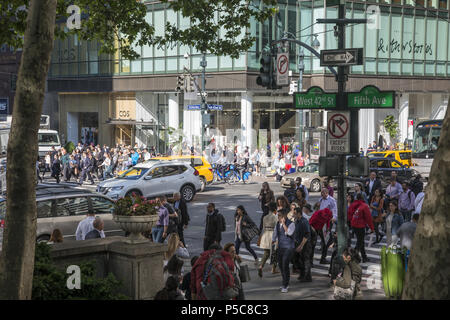 Il crosswalk alla Quinta Avenue e la 42th Street è sempre affollato di midtown Manhattan, a New York City. Foto Stock