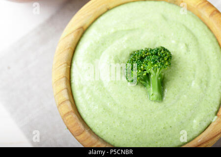 Crema di zuppa di broccoli su un bianco sullo sfondo di legno, vista dall'alto Foto Stock