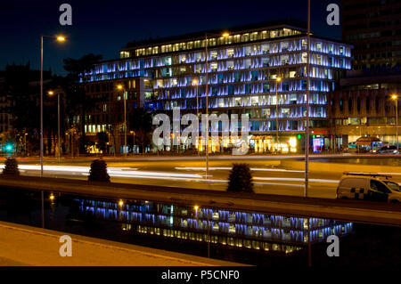 Moderno edificio di uffici, di notte, illuminato, che si riflette in un stagno di Madrid. Spagna. Foto Stock