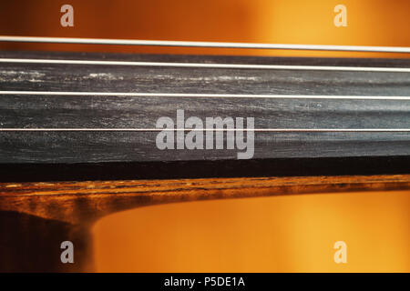 Dettagli di un vecchio polveroso violoncello, closeup vista sulle stringhe e corpo. Foto Stock