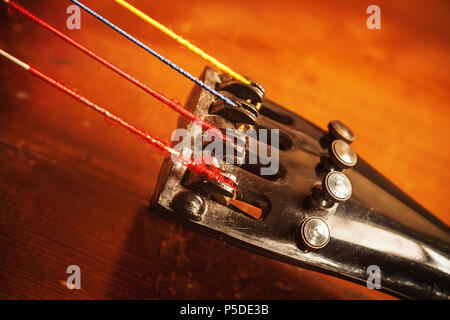 Dettagli di un vecchio polveroso violoncello, closeup vista sulle stringhe e corpo. Foto Stock