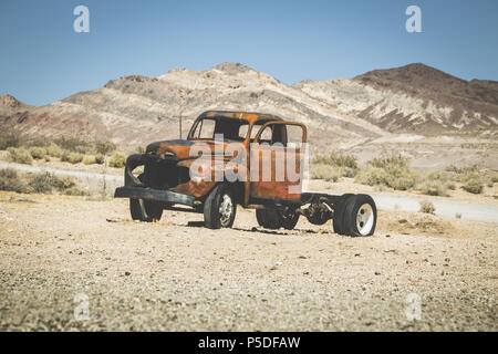 Visualizzazione classica di un vecchio arrugginito pickup truck auto rottamata nel deserto su una bella giornata di sole con cielo blu in estate con retro vintage VSCO Instagram s Foto Stock