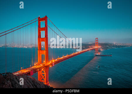 Classic vista panoramica del famoso Golden Gate con merci nave in splendida post tramonto crepuscolo durante ore Blu al tramonto in estate, San Francesco Foto Stock