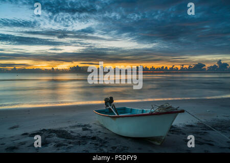 Una splendida alba tropicale con una barca sulla spiaggia. Foto Stock