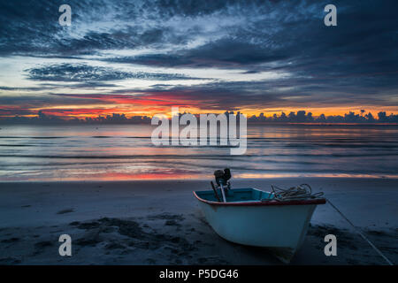 Una splendida alba tropicale con una barca sulla spiaggia. Foto Stock