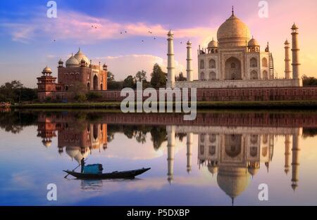 Taj Mahal Agra al tramonto con moody sky con la barca di legno sul fiume Yamuna Foto Stock