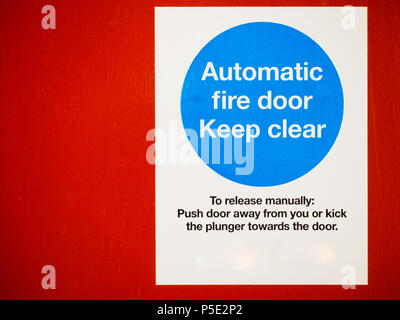 Porta antincendio automatica mantenere chiaro segno su una porta rossa Foto Stock