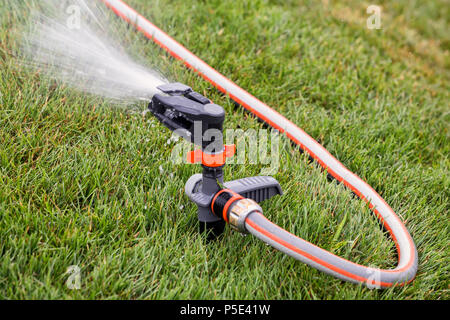 Irrigatore automatico per prato da giardino in azione per irrigare l'erba