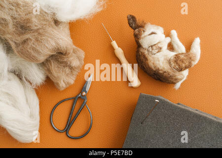 Ago feltro coniglio selvatico di dormire su in finta pelle con utensili per la produzione di feltri Foto Stock