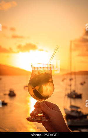 Un glaass con cocktail mojito contro il cielo al tramonto in Isole Vergini Britanniche Foto Stock