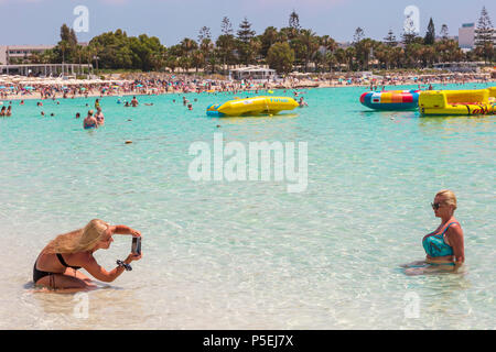 Due turisti femmina scattare fotografie mentre nel mare di nessi Beach resort, nei pressi di Agia Napa, Cipro Foto Stock