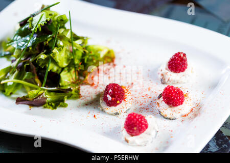 Insalata fresca con formaggio di capra e lampone. Foto Stock