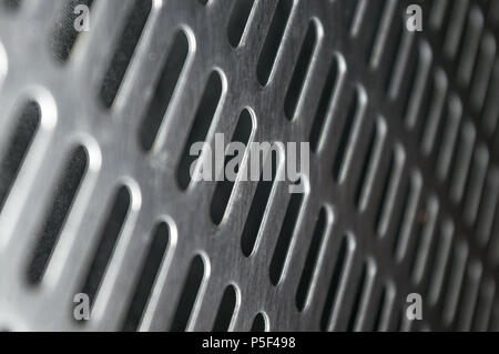 Acciaio inossidabile griglia con fori oblunghi su sfondo nero, close-up Foto Stock