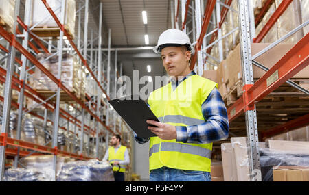 Lavoratore di magazzino con appunti nel giubbotto di sicurezza Foto Stock