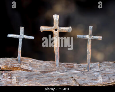 Realizzato a mano croce di ferro visualizzato in un negozio di fabbro ferraio. Gli sfondi in blur per disattivare il suo santo sensazione. Foto Stock