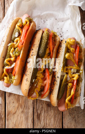 Delizioso stile di Chicago hot dog con senape, verdure e assaporare da vicino sul tavolo. verticale in alto vista da sopra Foto Stock