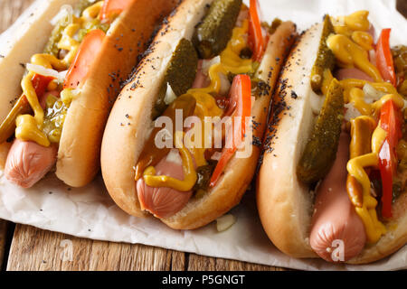 Lo stile di Chicago hot dog con senape, pomodori e cetrioli sottaceto, cipolle e salsa di close-up sul tavolo orizzontale. Foto Stock