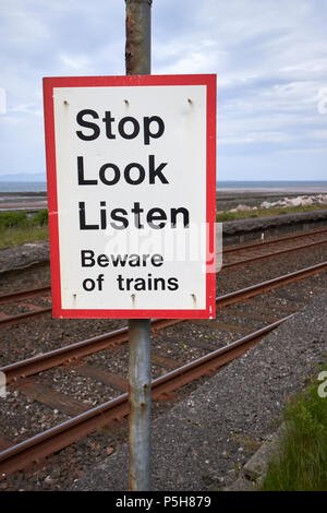 Smettere di guardare ascoltare un cartello di segnalazione a unmanned pedonale di attraversamento di livello sul treno costiero via Cumbria Inghilterra England Regno Unito Foto Stock