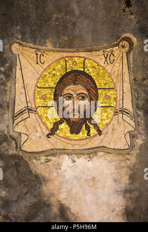 Illustrazione di mosaico di testa di Gesù Cristo con il guidacarta dorato e coperta su pietra di roccia di montagna a inferiore di Ostrog Monastero, Danilovgrad, Montenegro. Foto Stock